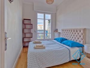- une chambre avec un lit doté d'oreillers bleus et d'une fenêtre dans l'établissement NEW Luxurious apartment - Jean Medecin, à Nice