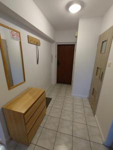 a bathroom with a wooden bench and a door at Emilka 2 in Suwałki