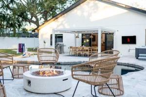 帕姆港1 Mile to Honeymoon Island ~Heated Pool ~Putt Putt的庭院里设有一组椅子和一个火坑