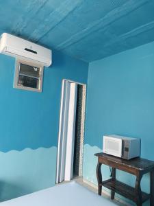 a microwave sitting on a table next to a window at Apartamentos no Farol Velho in Salinópolis