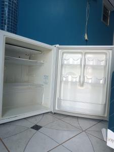 Apartamentos no Farol Velho في سالينوبوليس: ثلاجة بيضاء وبابها مفتوح في مطبخ