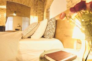 - une chambre avec un lit avec des oreillers et un vase de fleurs dans l'établissement Tomy Old Town Apartments, à Vilnius