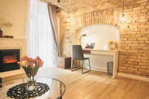 un salon avec une table en verre et un mur en briques dans l'établissement Tomy Old Town Apartments, à Vilnius