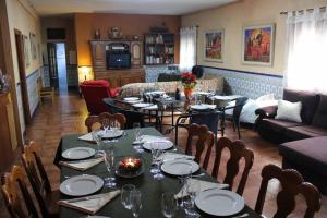 a dining room with tables and chairs and a couch at La Casona de Toledo in Gerindote