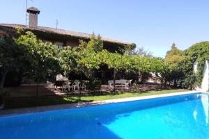 a villa with a swimming pool and a house at La Casona de Toledo in Gerindote