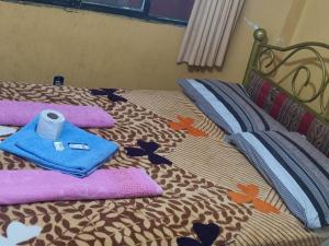 - un lit avec des serviettes et un rouleau de papier toilette dans l'établissement Hostal Arco Iris, à Copacabana