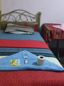 a tshirt and a roll of toilet paper on a bed at Hostal Arco Iris in Copacabana