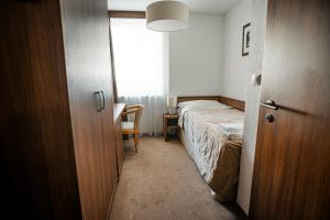 a small bedroom with a bed and a window at Šport Hotel *** Donovaly in Donovaly
