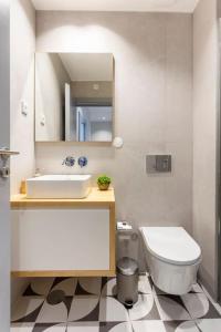ein Badezimmer mit einem Waschbecken, einem WC und einem Spiegel in der Unterkunft Almada 505 City Center Duplex in Porto
