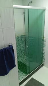 y baño con ducha de cristal y toalla azul. en Apartamento Sun Barra Tijuca frente Mar, en Río de Janeiro