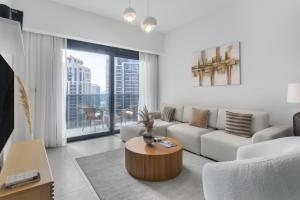 Downtown Dubai- 2BR Apartment in ACT Towers في دبي: غرفة معيشة مع أريكة وطاولة
