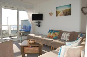 a living room with a couch and a table at Ann's Beach House in Tywyn in Tywyn