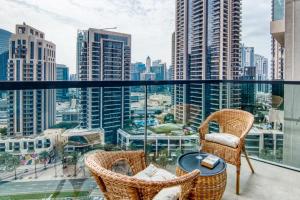 a balcony with chairs and a view of the city at Downtown Dubai- 2BR Apartment in ACT Towers in Dubai
