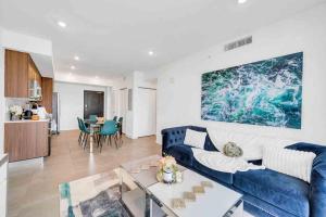 uma sala de estar com um sofá azul e uma mesa em Amazing 3 Bed Unit in DWNTWN Miami With Free Parking em Miami