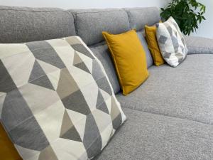 a gray couch with three pillows on top of it at Varese Apartment in Varese