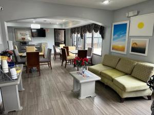 Days Inn by Wyndham Decatur Priceville I-65 Exit 334 في ديكاتور: غرفة معيشة مع أريكة وكراسي وطاولة