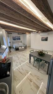 ein großes Wohnzimmer mit einem Tisch und einem Sofa in der Unterkunft Ca lucia Canal View in Venedig