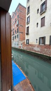 um barco em uma massa de água com edifícios em Ca lucia Canal View em Veneza