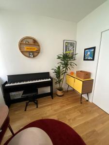 a living room with a piano and a table at Maison de ville d'architecte parking gratuit in Paris