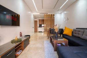 een woonkamer met een bank en een tv bij Royal KING Bed SUITE W/POOL in Marrakesh