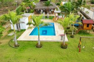 an aerial view of a house with a swimming pool and palm trees at Brisas de barú in Ararca