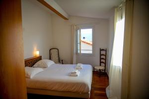 um quarto com uma cama branca e uma janela em Rosella - Terrasse rooftop, hypercentre, wifi - by TGB em Ajaccio
