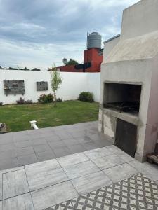 un patio con chimenea de piedra junto a una pared blanca en Monoambiente Serena Depto, en Mar del Plata