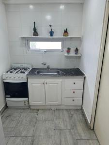 Una pequeña cocina con fregadero y estufa. en Monoambiente Serena Depto, en Mar del Plata 3 fotos más
