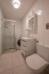 y baño con aseo, lavabo y lavadora. en 2 quartos em Ipanema com vista para Lagoa e Cristo, en Río de Janeiro