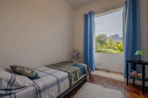 1 dormitorio con cama y ventana grande en 2 quartos em Ipanema com vista para Lagoa e Cristo, en Río de Janeiro
