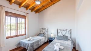 ein Schlafzimmer mit zwei Betten und einem Fenster in der Unterkunft Casa Tortela Almáchar by Ruralidays in Almáchar + 22 Fotos
