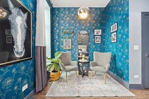 un pasillo con paredes azules, 2 sillas y una mesa en McCormick Place Guest House, en Chicago