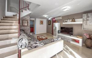 ein Wohnzimmer mit einem Sofa, einem TV und einer Treppe in der Unterkunft Amazing Home In Playa De Almazora With Kitchen in San Antonio