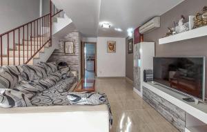 ein Wohnzimmer mit einem Sofa und einem TV in der Unterkunft Amazing Home In Playa De Almazora With Kitchen in San Antonio