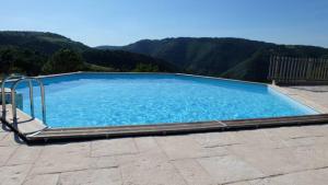 a large blue swimming pool with mountains in the background at Gites de la Bastide, 30750 Trèves in Tréves