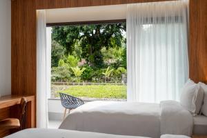 um quarto com 2 camas e uma grande janela em Vert Hotel Penedo em Penedo mais 37 fotografias