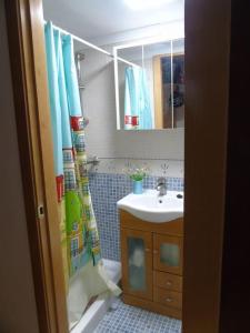 uma casa de banho com um lavatório e uma cortina de chuveiro em Acogedor apartamento de montaña em Sierra Nevada