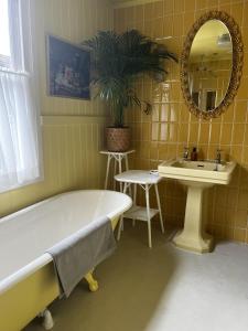 a bathroom with a tub and a sink and a mirror at Hastings Old Town Gorgeousness in Hastings
