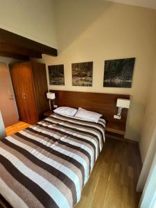 a large bed in a room with three pictures on the wall at Résidence CERDANYA in Bourg-Madame