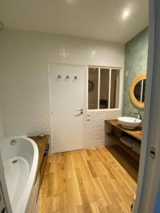 uma casa de banho com uma banheira e um lavatório em Maison de ville d'architecte parking gratuit em Paris