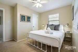 a bedroom with a large white bed with a ceiling fan at Walk to Zilker Patio w a View Elevated Balcony in Austin