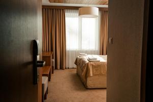 a hotel room with a bed and a window at Šport Hotel *** Donovaly in Donovaly
