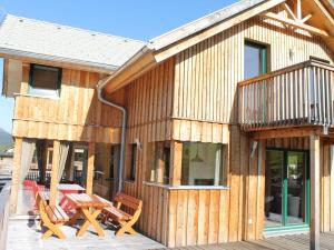 ein Holzhaus mit einem Tisch und Stühlen auf einer Terrasse in der Unterkunft Exclusive chalet in Hohentauern in ski area in Hohentauern