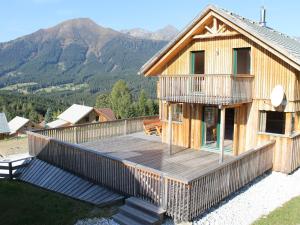 ein Haus mit einer Terrasse mit Bergen im Hintergrund in der Unterkunft Exclusive chalet in Hohentauern in ski area in Hohentauern