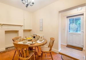 a kitchen and dining room with a table and chairs at Old Fishermans Cottage - East Runton in West Runton