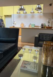 una sala de estar con una mesa de cristal con copas de vino. en Victoria Park Apartment en Londres