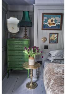 a bedroom with a green dresser and a green lamp at House in Hastings in Hastings
