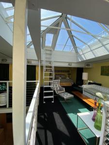 Habitación con techo de cristal, escalera y sofá. en Victoria Park Apartment en Londres