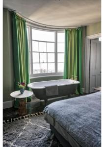 a bedroom with a tub and green curtains and a bed at House in Hastings in Hastings