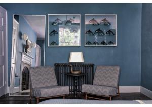 a blue room with two chairs and a table and a window at House in Hastings in Hastings +18 photos
